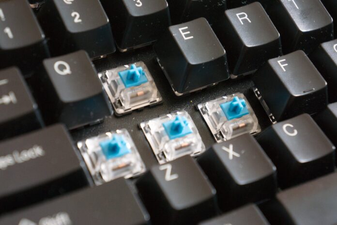 keebImg An image of a mechanical keyboard, with the W A S D keycaps removed to expose the blue switches in clear housing in the keyboard